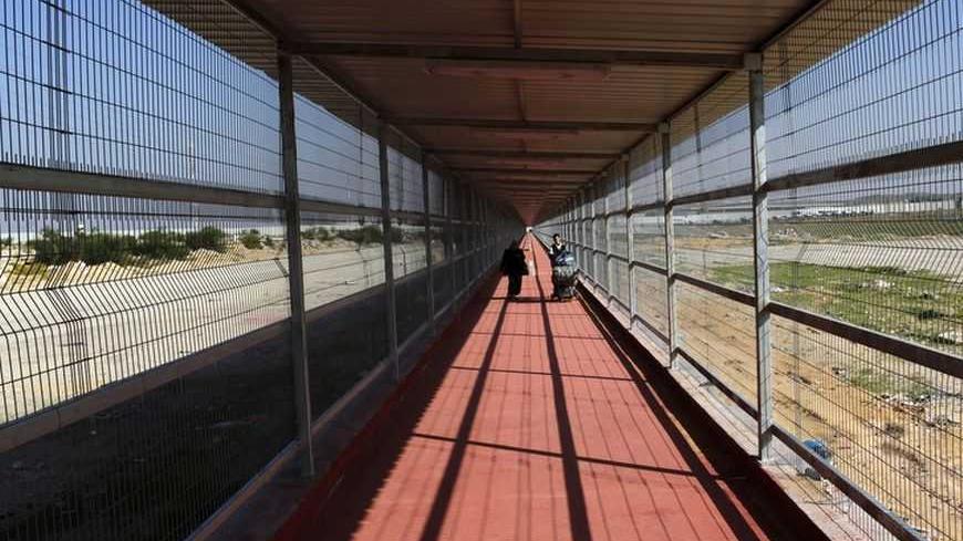 Palestinians walk through a newly built 500 meter-long passage way on their way back to the Gaza Strip through Israel's Erez Crossing December 3, 2009.  REUTERS/Yannis Behrakis (GAZA POLITICS) - RTXRERB