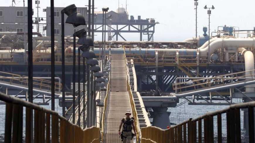 A soldier walks on the platform of the Basra Oil Terminal, 12 nautical miles off the Iraqi coast in the waters of the Northern Arabian Gulf, close to the port town of Umm Qasr August 8, 2006. The terminal is the main source of Iraq's revenues, a key supplier to the global energy market and an obvious target for insurgents aiming to thwart the country's economic recovery. Picture taken August 8, 2006.   REUTERS/Thaier Al-Sudani  (IRAQ) - RTR1GA9M