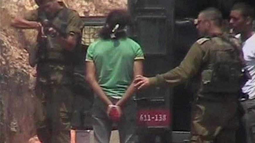 An Israeli soldier fires towards the leg of a Palestinian detained during a protest against the controversial Israeli barrier in the West Bank village of Nilin, in this frame grab from a video taken about three weeks ago and released on July 20, 2008, by Israeli rights group B'Tselem.  The video footage of the Israeli soldier firing what appears to be a rubber bullet at point-blank range at a bound and blindfolded Palestinian detainee has led to an army investigation. REUTERS/B'Tselem via Reuters TV  (WEST 