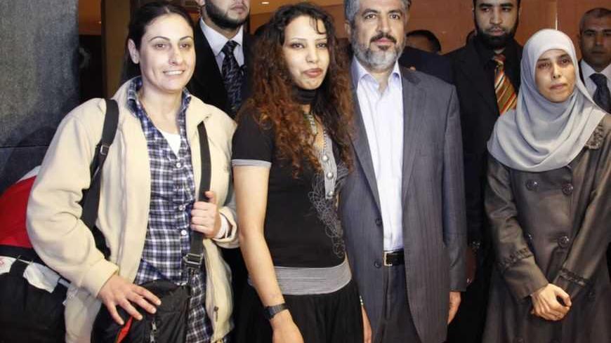 Palestinian former women prisoners pose with Hamas leader Khaled Meshaal after they were released and deported from Israeli jails and arrived in Cairo, October 18, 2011. Israeli soldier Gilad Shalit and hundreds of Palestinians crossed Israel's borders in opposite directions on Tuesday as a thousand-for-one prisoner exchange brought joy to families but did little to ease decades of conflict.  REUTERS/Jamal Saidi  (EGYPT - Tags: CIVIL UNREST POLITICS) - RTR2ST34
