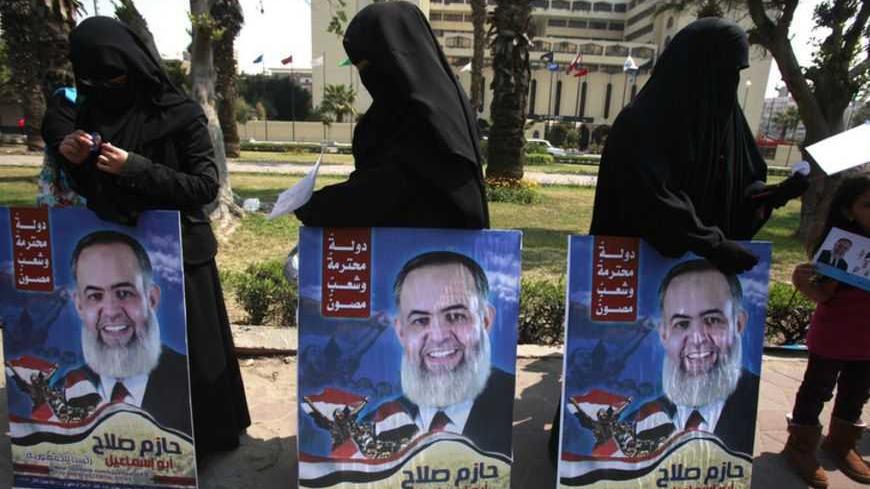 Supporters of Hazem Salah Abu Ismail, a Salafist leader and presidential candidate, carry his posters before his arrival to present recommendation documents to the Higher Presidential Elections Commission (HPEC) headquarters in Cairo March 30, 2012. The presidential election will be held on May 23 and 24.     REUTERS/Asmaa Waguih (EGYPT - Tags: POLITICS ELECTIONS) - RTR304AE