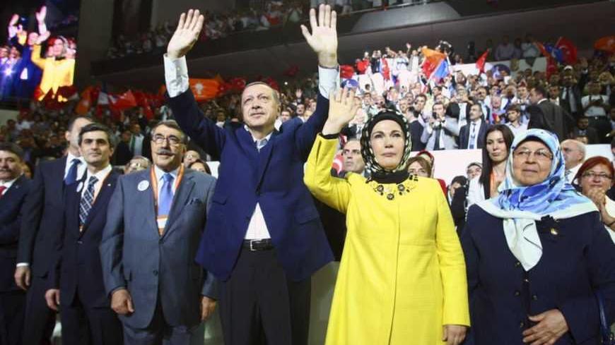 Turkey's Prime Minister and leader of ruling Justice and Development Party (AKP) Tayyip Erdogan (C), accompanied by his wife Emine Erdogan (front 2nd R), greets his supporters as he enters the hall during his party congress in Ankara September 30, 2012. REUTERS/Adem Altan/Pool (TURKEY - Tags: POLITICS) - RTR38LZQ