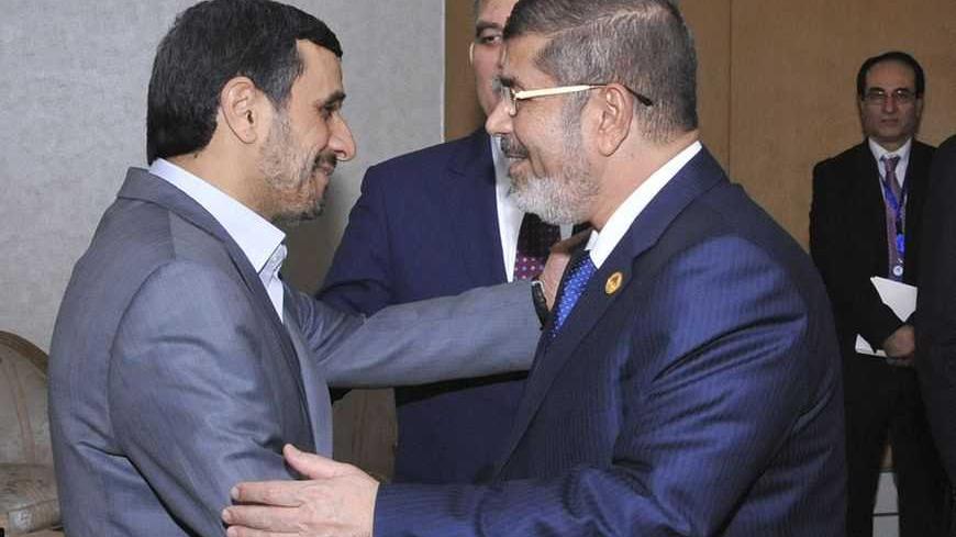 Egyptian President Mohamed Mursi (R) greets Iran's President Mahmoud Ahmadinejad as Turkish President Abdullah Gul look on before meeting at the Organisation of Islamic Cooperation (OIC) summit in Cairo February 6, 2013. Leaders of Islamic nations called for a negotiated end to Syria's civil war at a summit in Cairo that began on Wednesday, thrusting Egypt's new Islamist president to centre stage amid turbulence at home. REUTERS/Egyptian Presidency/Handout (EGYPT - Tags: POLITICS) ATTENTION EDITORS - THIS I