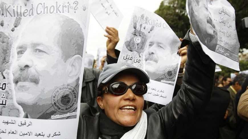 A woman chants slogans and holds pictures of assassinated leftist politician Chokri Belaid during a demonstration against the Islamist Ennahda movement in Tunis February 23, 2013.   REUTERS/Zoubeir Souissi (TUNISIA - Tags: CIVIL UNREST POLITICS) - RTR3E69D