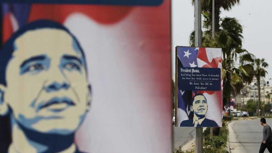 A Palestinian man walks near placards designed by an activist depicting U.S. President Barack Obama, ahead of his visit to the region, in the West Bank city of Ramallah March 12, 2013. The White House has yet to officially announce the dates for the trip, but Israeli news media have reported that Obama will arrive in the region on March 20. REUTERS/Ammar Awad (WEST BANK - Tags: POLITICS) - RTR3EVUU