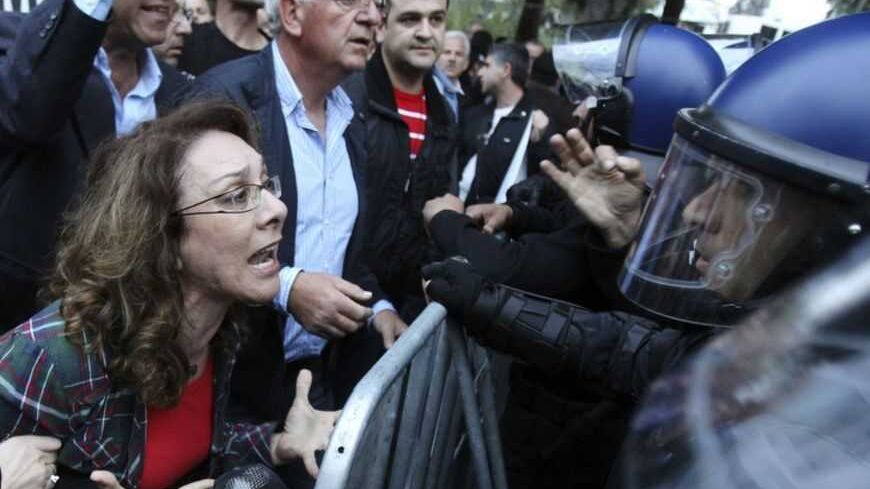 A protester yells at policemen during a protest by employees of Cyprus Popular Bank outside the parliament in Nicosia March 21, 2013. The Cypriot central bank denied reports and frantic rumours on Thursday that stricken Cyprus Popular Bank, the island's second-largest lender, is to be closed down.        REUTERS/Andreas Manolis  (CYPRUS - Tags: POLITICS BUSINESS CIVIL UNREST TPX IMAGES OF THE DAY) - RTR3FA5X