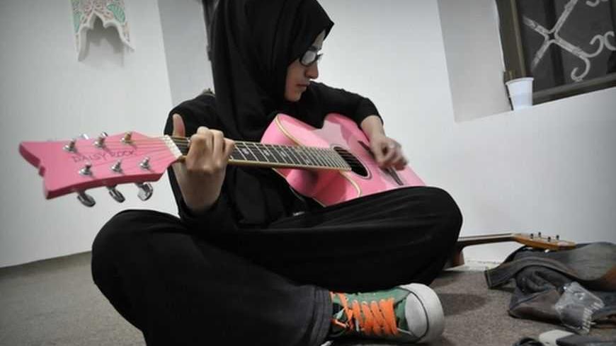 Methal Hamadi with her pink guitar in the music room of the Basement