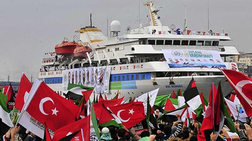 Pro-Palestinian activists wave Turkish and Palestinian flags during the welcoming ceremony for cruise liner Mavi Marmara at the Sarayburnu port of Istanbul December 26, 2010. Nine Turkish activists died in May when Israeli commandos raided the boat, which was part of a flotilla seeking to break the blockade imposed on the Gaza Strip. REUTERS/Stringer  (TURKEY - Tags: POLITICS CIVIL UNREST IMAGES OF THE DAY) - RTXW0M8