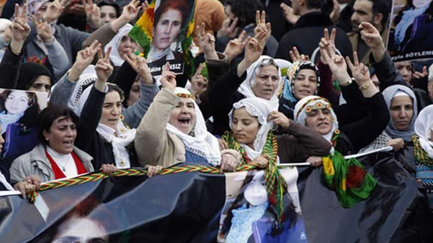 Pro-Kurdish demonstrators march with a banner bearing the picture of slain Kurdish activist Sakine Cansiz (L) during a protest at Ataturk International Airport in Istanbul January 16, 2013. Turkish Prime Minister Tayyip Erdogan said on Wednesday military operations against Kurdish rebels would continue until they laid down their arms, as Turkish media reported warplanes had bombed militants in northern Iraq for a third day. REUTERS/Osman Orsal (TURKEY - Tags: POLITICS CIVIL UNREST) - RTR3CJ21