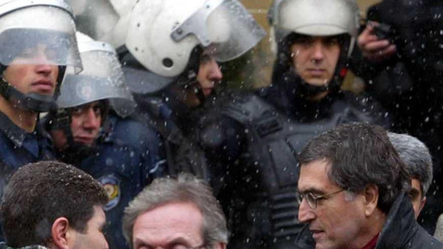 Turkish columnist Hasan Cemal (R), one of five journalists who are on trial for insulting the country's courts, leaves the court house following their trial in Istanbul, February 7, 2006. A Turkish court on Tuesday began hearing the case of five prominent journalists who face possible jail sentences in a trial which is seen as a fresh test of curbs on freedom of expression in the European Union candidate nation. REUTERS/Stringer - RTR1A80J