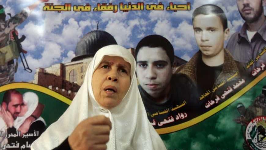 Mariam Farhat, a Hamas woman candidate for the upcoming Palestinian parliament, is seen in front of a large mural of her three dead sons inside her house in Gaza December 8, 2005. The Islamic militant group Hamas has chosen the mother of three "martyrs" who died fighting Israel to run for Palestinian parliament in a race where Hamas will likely pose a tough challenge to President Mahmoud Abbas's Fatah party. REUTERS/Suhaib Salem Pictures of the Month December 2005 - RTR1AJ4O