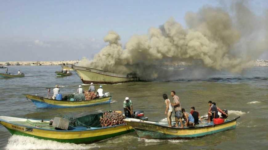 Palestinian fishermen gather around a fishing boat after it was hit by Israeli army naval fire at Gaza's seaport August 31, 2009. An Israeli army spokesperson said on Monday, fishermen on the boat violated security boundaries of the coast of Gaza Strip crossing into an area out of permitted fishing zone. REUTERS/Ismail Zaydah (GAZA POLITICS CONFLICT IMAGES OF THE DAY) - RTR27AGR