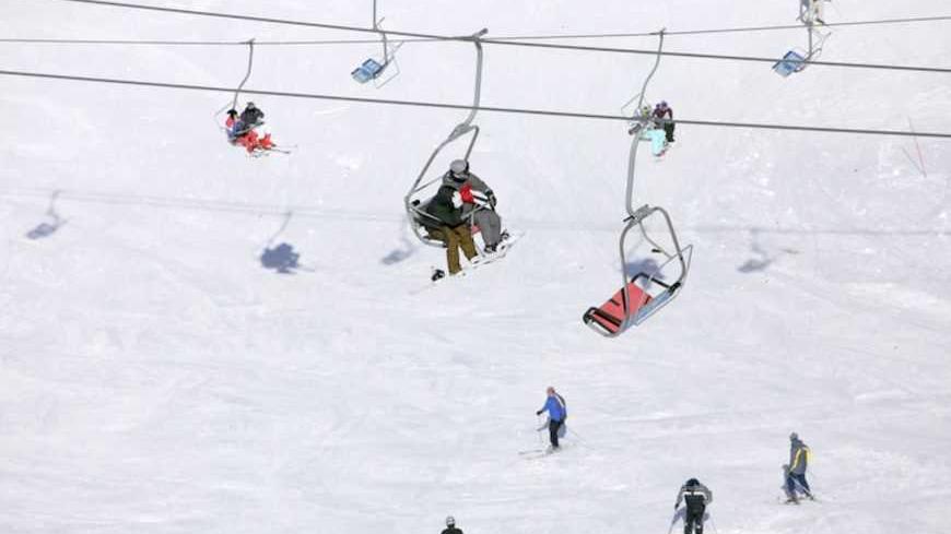 Snow boarders ride a ski lift on Mount Hermon in the Golan Heights near the Israel-Syria border February 7, 2010. The Golan Heights form a strategic plateau between Israel and Syria of about 1,200 square kilometers (460 square miles). Israel captured it in the 1967 Middle East war and annexed it in 1981 in a move not recognized internationally. REUTERS/Darren Whiteside  (ISRAEL - Tags: ENVIRONMENT TRAVEL SOCIETY) - RTR29XGT