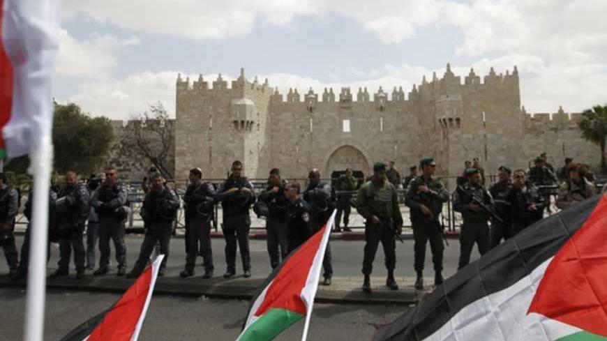 Protesters hold Palestinian flags opposite Israeli security officers standing guard before Friday prayers on Land Day outside Damascus Gate in Jerusalem's Old City March 30, 2012. Israeli security forces fired rubber bullets, tear gas and stun grenades to break up groups of Palestinian stone-throwers on Friday as annual Land Day rallies turned violent. Police said they had made five arrests at Damascus Gate. Land Day commemorates the killing by security forces of six Arabs in 1976 during protests against go