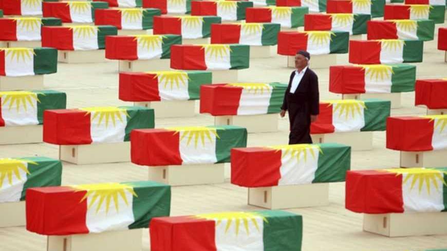 A Kurdish man walks between coffins draped with Kurdish flag containing the remains of victims during a burial ceremony in Sulaimaniya, 260km (162 miles) northeast of Baghdad, May 28, 2012. More than 700 Kurds, killed by former Iraqi leader Saddam Hussein, were honoured in a ceremony in northern Iraq on Monday. Kurdish officials gathered at the Police Academy in Suleimaniya province to mourn 730 victims of Iraq's notorious 'Anfal' campaign, whose bodies were discovered in mass graves in southern Iraq in Jul