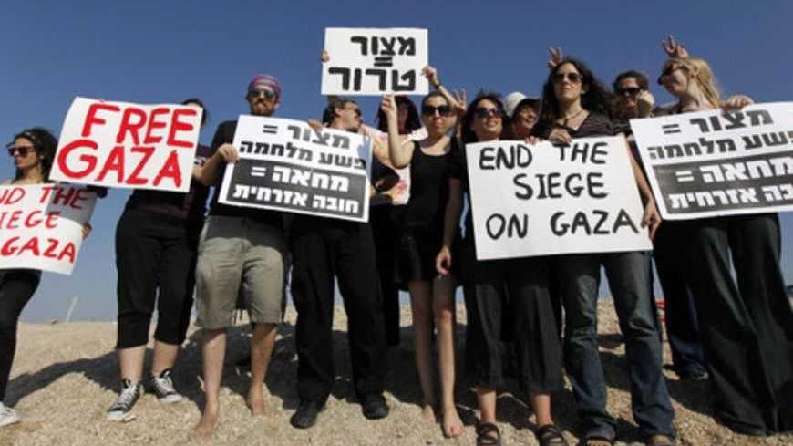 Israeli activists hold signs in support of Gaza near the entrance to the port of Ashdod  October 20, 2012. The Israeli navy seized an international pro-Palestinian activist ship in the Mediterranean sea on Saturday to prevent it breaching its blockade of the Gaza Strip, a military spokeswoman said. She said no one was hurt when marines boarded the SV Estelle, a three-mast schooner, and that it was rerouted to Israel's southern port of Ashdod after it ignored orders to turn away from the Hamas-governed Pales