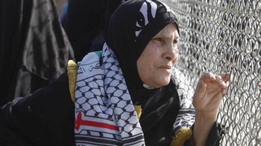 A Palestinian woman waits for the return of Fatah movement activists at the Rafah border crossing in the southern Gaza Strip December 3, 2012. The Islamist Hamas group allowed the 10 activists of Palestinian President Mahmoud Abbas' Fatah movement, who fled Gaza into Egypt in 2007 during internal fighting between the two political rivals, to return home in what the group said was a sign of rapprochement, according to a Hamas official.  REUTERS/Ibraheem Abu Mustafa (GAZA - Tags: POLITICS CIVIL UNREST) - RTR3