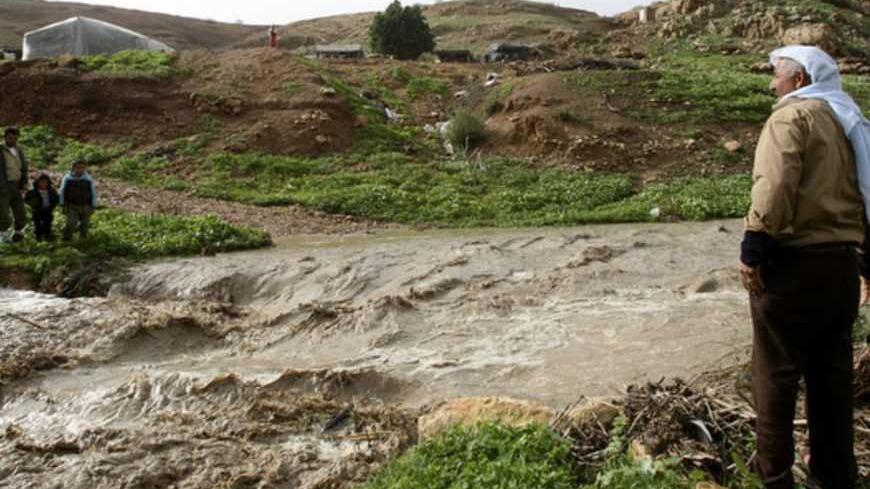 Palestinians look at water in an overflowing stream in the West Bank village of Al-Nassariyeh near Nablus January 8, 2013. REUTERS/Abed Omar Qusini (WEST BANK - Tags: ENVIRONMENT) - RTR3C7WK