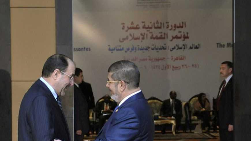 Egyptian President Mohamed Mursi (R) greets Iraq's Prime Minister Nouri al-Maliki before the opening of the Organisation of Islamic Cooperation (OIC) summit in Cairo February 6, 2013. Leaders of Islamic nations called for a negotiated end to Syria's civil war at a summit in Cairo that began on Wednesday, thrusting Egypt's new Islamist president to centre stage amid political and economic turbulence at home. REUTERS/Egyptian Presidency/Handout (EGYPT - Tags: POLITICS) ATTENTION EDITORS - THIS IMAGE WAS PROVI