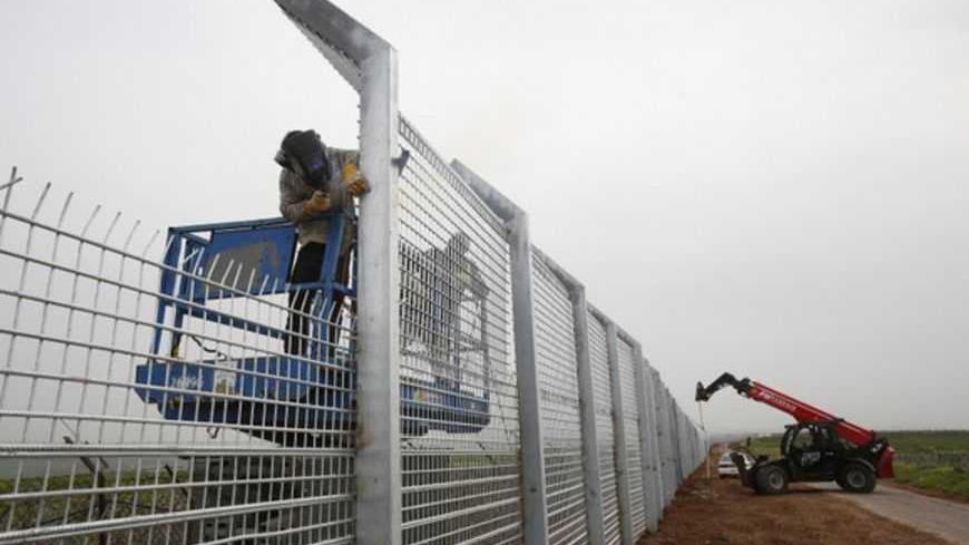 Labourers reinforce the fence near Israel's border with Syria in the Golan Heights February 14, 2013. Israel captured the Golan Heights from Syria in the 1967 Middle East war and annexed the territory in 1981, a move not recognised internationally. REUTERS/Baz Ratner (POLITICS) - RTR3DSEM