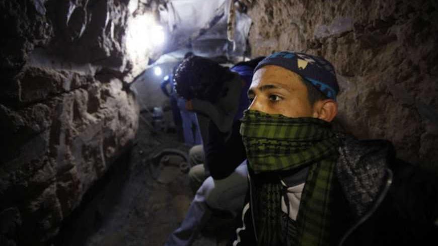 A Palestinian works inside a smuggling tunnel flooded by Egyptian forces, beneath the Egyptian-Gaza border in Rafah, in the southern Gaza Strip February 19, 2013. Egypt will not tolerate a two-way flow of smuggled arms with the Gaza Strip that is destabilising its Sinai peninsula, a senior aide to its Islamist president said, explaining why Egyptian forces flooded sub-border tunnels last week. To match Interview PALESTINIANS-TUNNELS/EGYPT REUTERS/Ibraheem Abu Mustafa (GAZA - Tags: POLITICS CIVIL UNREST) - R