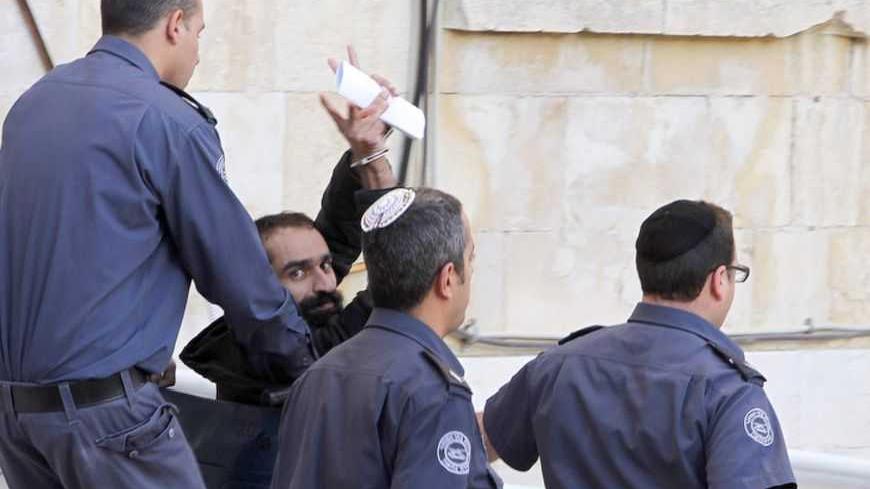 Samer al-Issawi, one of four Palestinians held by Israel who has been on an intermittent hunger strike, gestures as he leaves Jerusalem's magistrates' court February 19, 2013. Hundreds of Palestinian prisoners in Israeli jails declared a one-day fast on Tuesday in solidarity with four inmates whose hunger strike has fuelled anti-Israel protests in the occupied West Bank. Gaunt and wheelchair-bound, Issawi appeared on Tuesday before the Jerusalem civil court, which deferred releasing him for at least another
