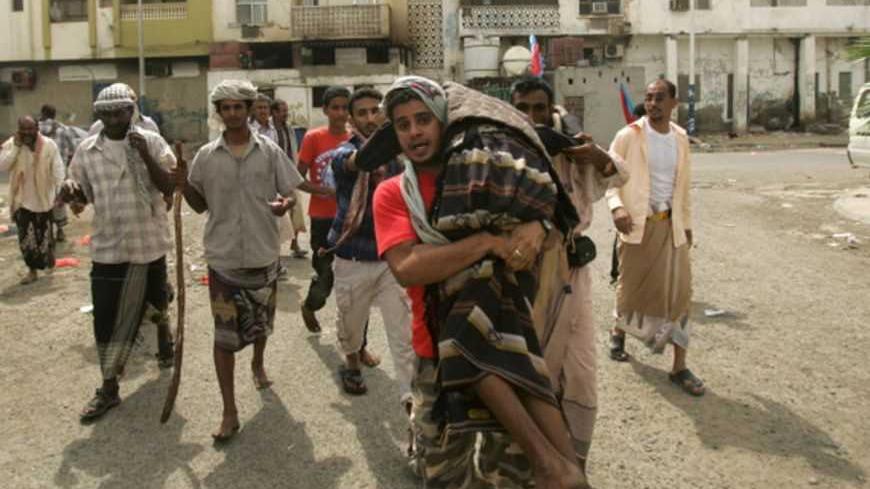 A supporter of the separatist Southern Movement is carried to an ambulance after he was injured during clashes with security forces in the southern Yemeni port city of Aden February 21, 2013, ahead of planned rallies to mark the first anniversary of ex-president Ali Abdullah Saleh's ouster. Yemen has struggled to restore normality since President Abd-Rabbu Mansour Hadi was elected in February 2012 following a year of protests that forced his predecessor Saleh to step down after 33 years in power. REUTERS/Kh