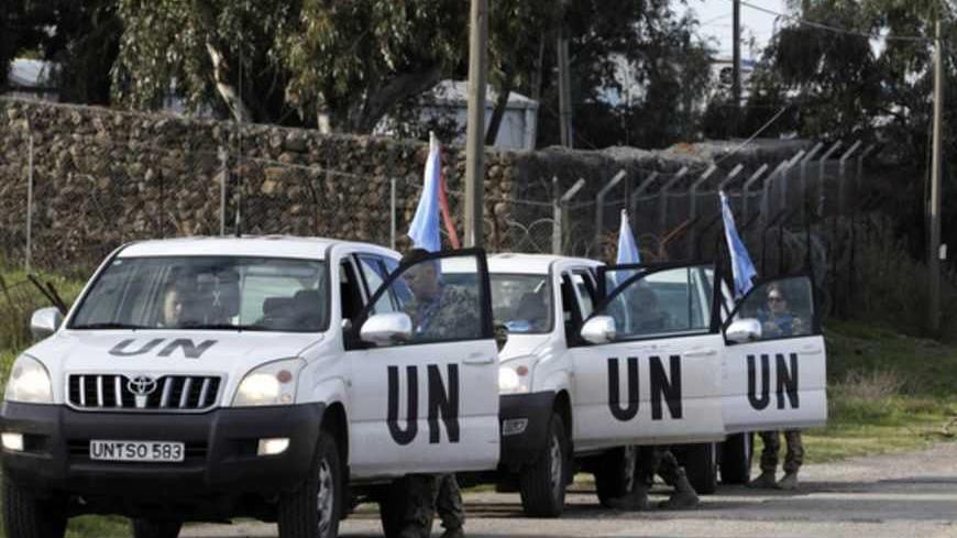 United Nations peacekeepers put on protective gear before driving through the Kuneitra border crossing between Israel and Syria, in the Israeli occupied Golan Heights March 8, 2013. Israel voiced confidence on Thursday that the United Nations could secure the release of U.N. peacekeepers seized by Syrian rebels near the Golan Heights on Wednesday, signalling it would not intervene in the crisis. Israel captured the Golan Heights in the 1967 Middle East war and annexed it in 1981 in a move not recognized int