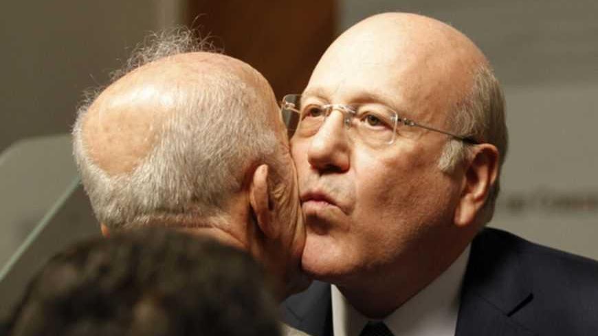 Lebanon's Prime Minister Najib Mikati kisses Deputy Prime Minister Samir Moqbel after announcing his resignation at the Grand Serail, the government headquarters in Beirut, March 22, 2013. Mikati announced his resignation on Friday after Shi'ite group Hezbollah and its allies blocked the creation of a body to supervise parliamentary elections and opposed extending the term of a senior security official. REUTERS/ Mohamed Azakir (LEBANON - Tags: POLITICS TPX IMAGES OF THE DAY) - RTR3FCES