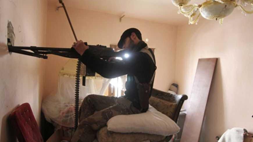 A Free Syrian Army fighter takes position inside a room as he points his weapon through a hole in Aleppo's Saif al-Dawla district March 20, 2013. REUTERS/Giath Taha (SYRIA - Tags: CONFLICT) - RTR3F8E4