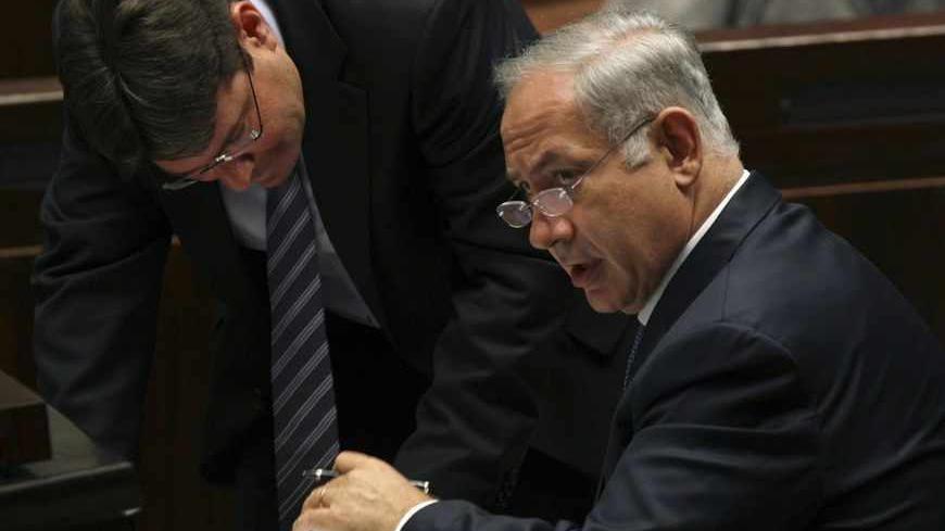 Israel's Prime Minister Benjamin Netanyahu (R) speaks with Knesset member Ofir Akonis after a non-confidence vote at the Knesset, the Israeli parliament, in Jerusalem June 8, 2009.  Netanyahu plans to deliver a major policy speech on Sunday aimed at addressing U.S. demands that he freeze settlement building and agree to negotiations on establishing a Palestinian state. REUTERS/Ronen Zvulun (JERUSALEM POLITICS) - RTR24G6O