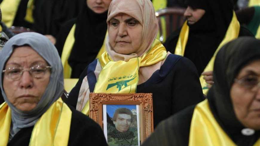 A woman carries a photo of a dead former Hezbollah fighter during a rally marking Hezbollah's Martyrs Day in Beirut's suburbs November 12, 2012. REUTERS/Sharif Karim (LEBANON - Tags: POLITICS CIVIL UNREST) - RTR3ABKX