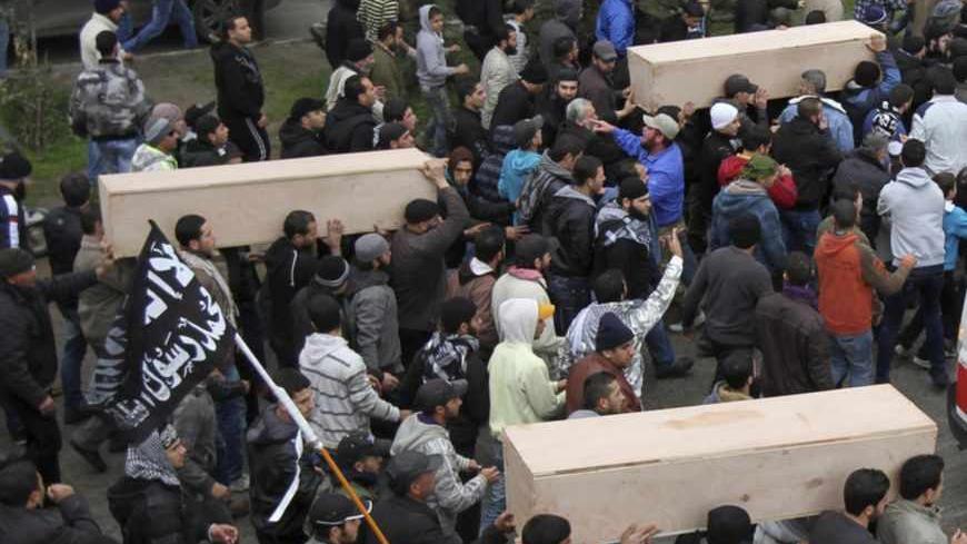 A general view of the crowd carrying coffins of Lebanese Islamist militants after their bodies arrived from Syria, in Tripoli, northern Lebanon December 22, 2012. Funerals will be held in Lebanon for three Lebanese Islamist militants killed while fighting with rebels in Syria. REUTERS/Omar Ibrahim (LEBANON - Tags: POLITICS CIVIL UNREST) - RTR3BU8U