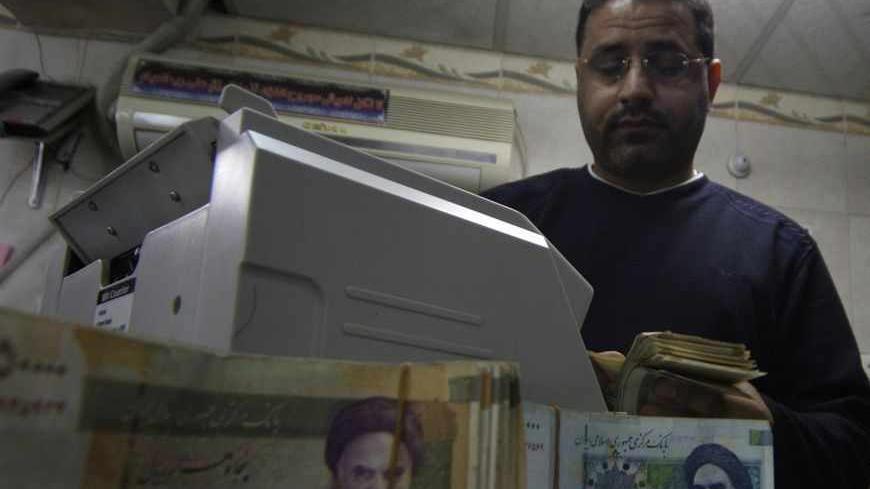 A man counts stacks of Iranian rials at a currency exchange shop in Kerbala , 110 km (70 miles) south of Baghdad January 23, 2013. Traders and owners of hotels in the holy city of Kerbala complain of sluggish business and a drop in Iranian pilgrims as a result of a sharp fall in the Iranian rial caused by a package of international sanctions imposed on the neighbouring country. REUTERS/Mushtaq Muhammed (IRAQ - Tags: SOCIETY BUSINESS) - RTR3CUEH