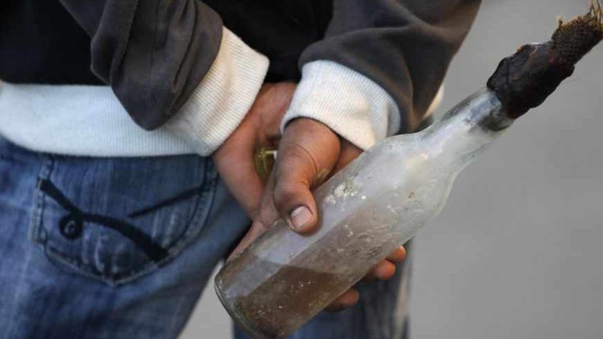 An anti-government protester holding a Molotov cocktail in his hand waits before clashes with riot police in the village of Sanabis, west of Manama February 14, 2013. REUTERS/ Hamad I Mohammed (BAHRAIN - Tags: CIVIL UNREST POLITICS) - RTR3DSHE