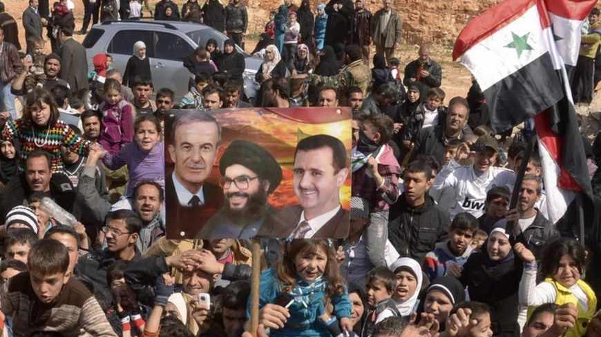 People chant slogans while holding Syrian national flags and a placard (C) with images of former Syrian President Hafez al-Assad (L), Syria's President Bashar al-Assad (R) and Lebanon's Hezbollah leader Sayyed Hassan Nasrallah during a protest in support of Bashar al-Assad in Aleppo March 9, 2013. REUTERS/George Ourfalian (SYRIA - Tags: CIVIL UNREST MILITARY POLITICS CONFLICT) - RTR3ERVA