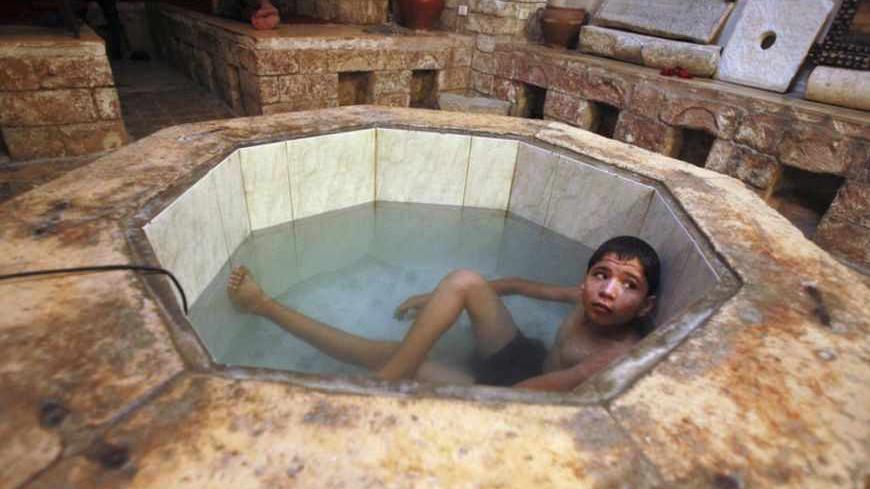 A Palestinian boy relaxes at the Hamam al-Samra, a traditional Turkish bath, in Gaza City October 27, 2010. The Hamam al-Samra, open 24 hours daily with separate hours for men and women, is about 1,000 years old and is frequented by local Palestinians for bathing purposes as well as treatment for various ailments.  REUTERS/Suhaib Salem (GAZA - Tags: SOCIETY) - RTXTVW3