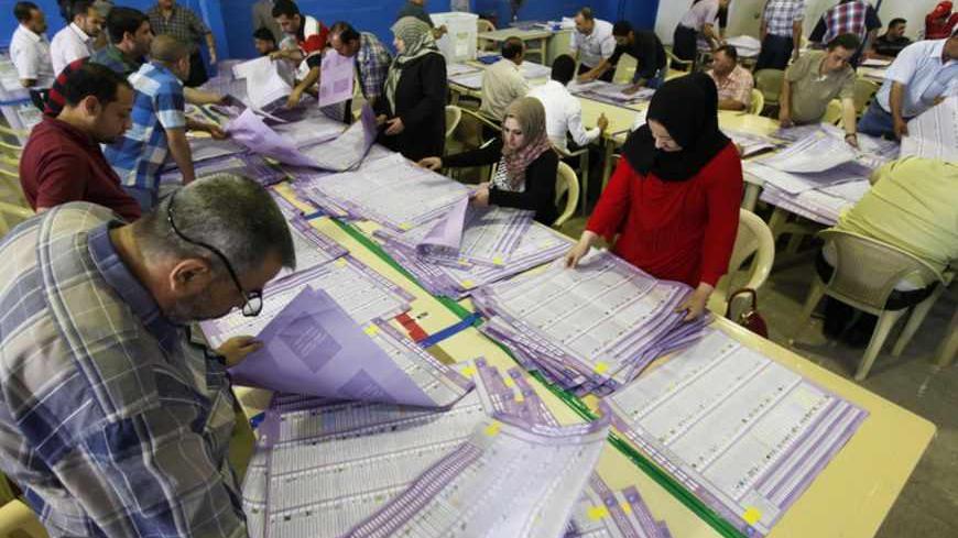 Employees of the Independent High Electoral Commission (IHEC) take part in vote counting at an analysis center in Baghdad April 23, 2013. Voter participation in Iraq's provincial election on Saturday was 50 percent of eligible voters, the country's electoral authorities said after poll stations closed. Election officials said including results from a special vote a week earlier for members of the armed forces, total participation would be more than 51 percent. REUTERS/Mohammed Ameen (IRAQ - Tags: POLITICS E
