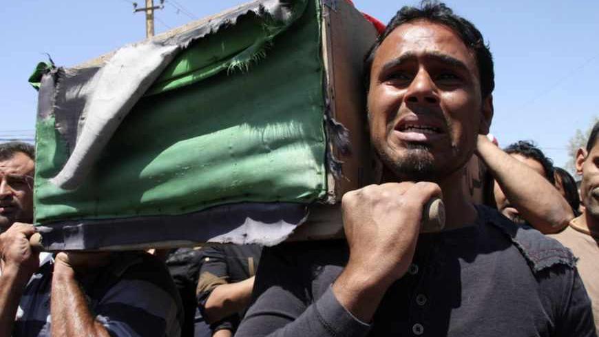 Residents carry a coffin during the funeral of an Iraqi soldier in Baghdad April 25, 2013. The soldier was killed on the second day of clashes following the storming of a Sunni Muslim protest camp by Iraqi forces, in Hawija, near Kirkuk, 170 km (100 miles) north of Baghdad. REUTERS/Wissm al-Okili (IRAQ - Tags: CIVIL UNREST POLITICS MILITARY) - RTXYZIZ