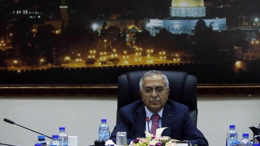 Palestinian Prime Minister Salam Fayyad sits at the head of a Palestinian cabinet meeting in the West Bank city of Ramallah April 16, 2013. Abbas accepted Fayyad's resignation on Saturday, but is likely to keep him in office for the next few weeks while the U.S. tries to revive Middle East peace talks, officials said on Monday. REUTERS/ Mohamed Torokman (WEST BANK - Tags: POLITICS) - RTXYNV1