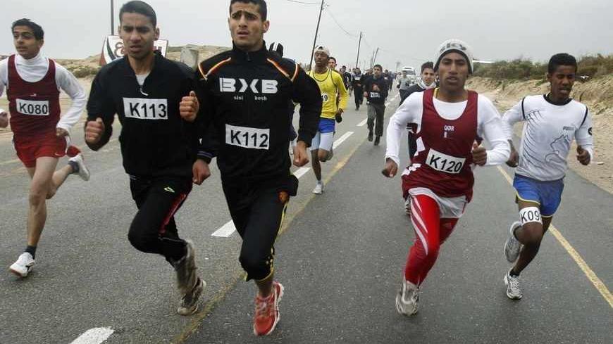 Runners take part in a 10 km race, as part of the second annual Gaza Marathon, organized by the United Nations Relief and Works Agency (UNRWA) in Khan Younis, in the southern Gaza Strip March 1, 2012. According to UNWRA, nearly 2,000 runners, Palestinians, foreigners and children, took part in the Gaza running events on Thursday, held to raise funds for the agency's 2012 Summer Games. REUTERS/Ibraheem Abu Mustafa (GAZA - Tags: SPORT POLITICS) - RTR2YOBB