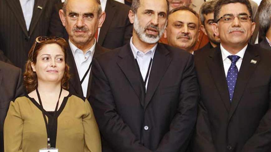 Syria's provisional prime minister Ghasssan Hitto (R), Syrian Opposition Coalition member Suheir Atassi (L) and Syrian National Coalition (SNC) President Mouaz al-Khatib (C) pose for the media after a news conference in Istanbul March 19, 2013. The opposition Syrian National Coalition chose Western-educated former businessman Ghasssan Hitto as provisional prime minister in a vote on Tuesday at a meeting in Istanbul. REUTERS/Osman Orsal (TURKEY - Tags: POLITICS CONFLICT CIVIL UNREST) - RTR3F6TV