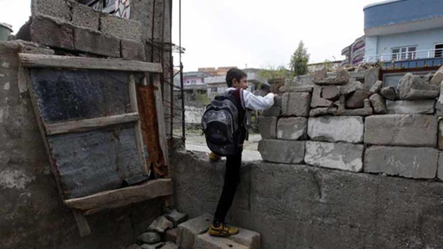 Ferhat Savun  aged 11, leaves his home for school in the town of Cizre in Sirnak province, near the border with Syria March 24, 2013. Turkey's fledgling peace process with the Kurdistan Workers Party (PKK) militant group is all over the headlines. After three decades of war, 40,000 deaths and a devastating impact on the local economy, everybody seems ready for peace. Pro-Kurdish politicians are focused on boosting minority rights and stronger local government for the Kurds, who make up about 20 percent of T