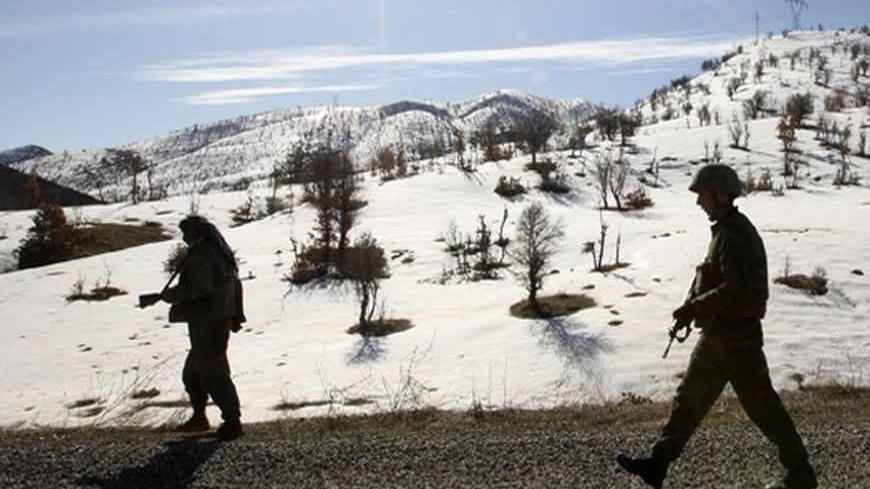 A Turkish soldier and a village guard patrol on a road near the southeastern Turkish city of Sirnak, near the Iraqi border, February 23, 2008. Thousands of Turkish troops have crossed into northern Iraq to hunt Kurdish rebels, television and a military source said on Friday, escalating a conflict that could undermine stability in the region.   REUTERS/Fatih Saribas  (TURKEY) - RTR1XGEI