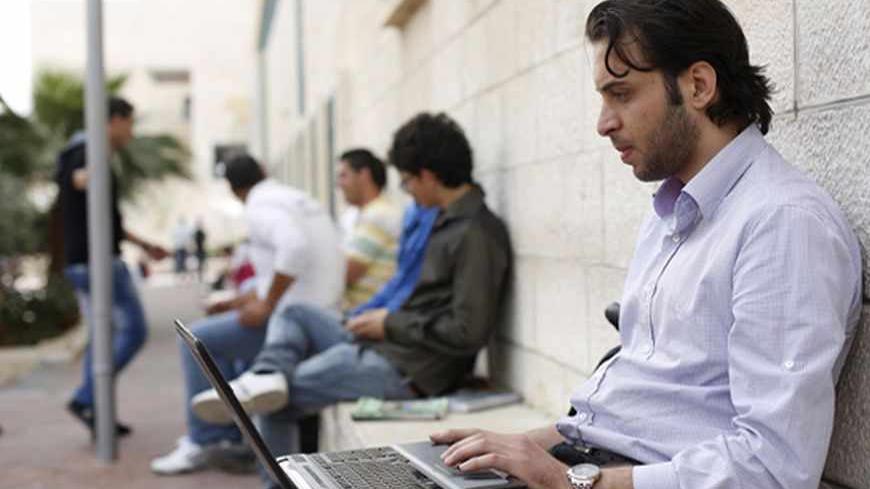Abdullah Yaseen, a freelance web programmer, works on his laptop at al-Najah University campus in the West Bank city of Nablus April 8, 2013. Fledgling Palestinian high-tech firms hope they can now help revitalise the economy, making the West Bank more resistant to Israeli controls on land and the movement of goods and people and less dependent on fickle foreign aid flows, which are blighting the public sector. Picture taken April 8, 2013. To match Feature PALESTINIANS-HITECH/     REUTERS/Mohamad Torokman (