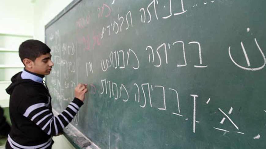 A Palestinian ninth grade student writes on the blackboard during a Hebrew class at a Gaza school in Gaza City January 28, 2013. REUTERS/Ahmed Zakot (GAZA - Tags: EDUCATION) - RTR3D31S