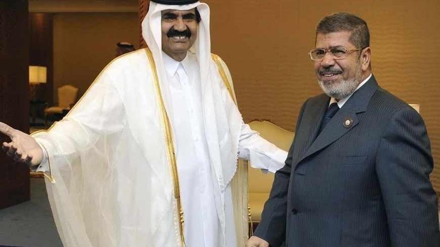 Qatar's Emir Sheikh Hamad bin Khalifa al-Thani (R) greets Egypt's President Mohamed Mursi during the Arab League summit in Doha March 26, 2013. Mursi said on Wednesday parliamentary elections could be delayed until October, a postponement that would give his cash-strapped government breathing room to negotiate an IMF deal. Picture taken March 26, 2013. REUTERS/Egyptian Presidency/Handout (EGYPT - Tags: POLITICS) ATTENTION EDITORS - THIS IMAGE WAS PROVIDED BY A THIRD PARTY. FOR  EDITORIAL USE ONLY. NOT FOR S
