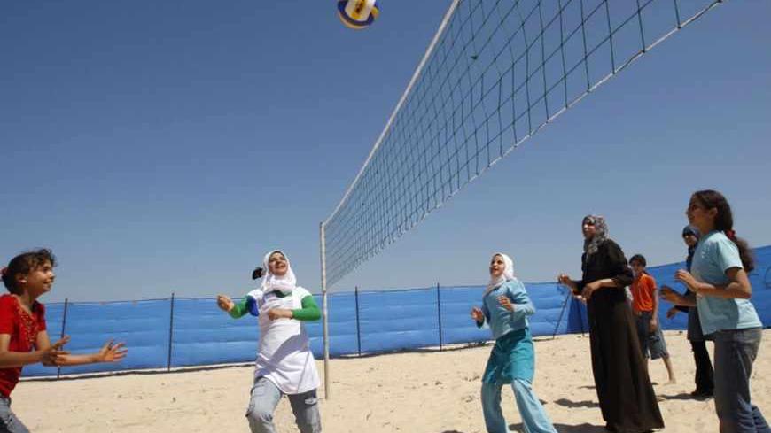 Palestinian girls play volleyball during a summer camp at the beach of Khan Younis in the southern Gaza Strip June 20, 2009. The camp is being organized by the United Nations Relief and Works Agency (UNRWA). REUTERS/Ibraheem Abu Mustafa (GAZA CONFLICT POLITICS SPORT VOLLEYBALL) - RTR24UHL