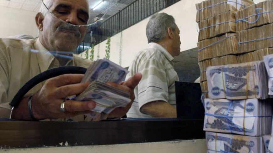 A client counts his money at Al-Rafidain bank in BaghdadJune 21, 2009. Total bank deposits in February -- the latest figures  available -- jumped by half to 36.6 trillion Iraqi dinars ($31 billion) from a year before, and loans surged 65 percent to 5.1 trillion dinars over the same period, central bank data show. 
 To match feature IRAQ/BANKS   REUTERS/Bassim Shati (IRAQ CONFLICT BUSINESS) - RTR2559B