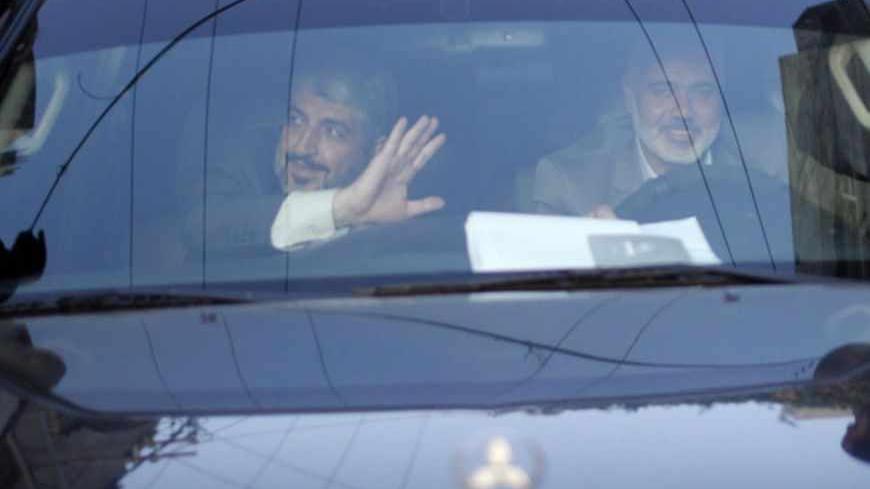 Hamas chief Khaled Meshaal (L) waves to people as he sits in a jeep beside senior Hamas leader Ismail Haniyeh in Rafah before leaving Gaza Strip December 10, 2012. Hamas leader Meshaal ended his first visit to the Gaza Strip on Monday with a pledge his Islamist movement would strive to heal political rifts with Palestinian rivals who hold sway in the occupied West Bank. REUTERS/Ahmed Jadallah (GAZA - Tags: POLITICS) - RTR3BFC0
